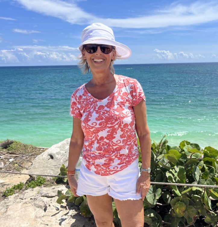 Ellen with a blue ocean and beach behind her
