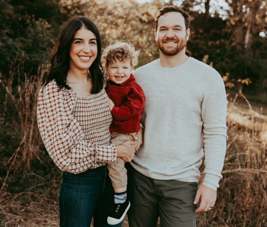 Stephen Huff smiling with his wife and son
