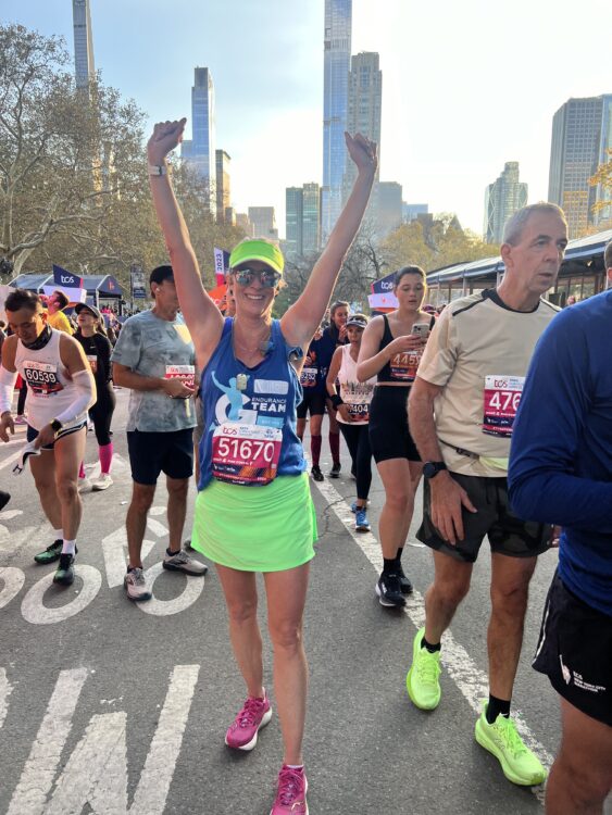 Meg at a race with her arms up