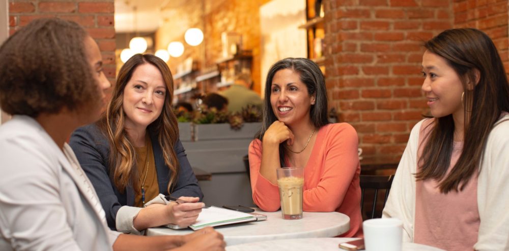 Women at a table talking together